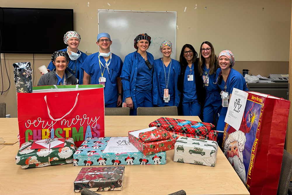 A group of UPMC Children's CRNAs and a table full of wrapped holiday presents