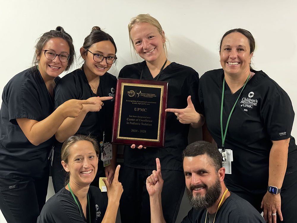 The Pediatric Sedation Service team at UPMC Children’s Hospital of Pittsburgh holding their center of excellence award plaque