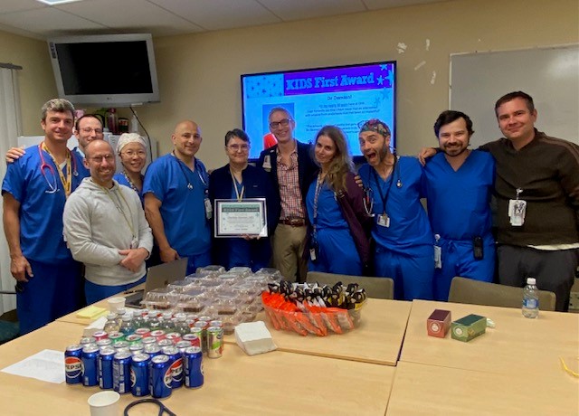 Daniela Damian holds her award surrounded by her anesthesiology colleagues at UPMC Children's Hospital of Pittsburgh