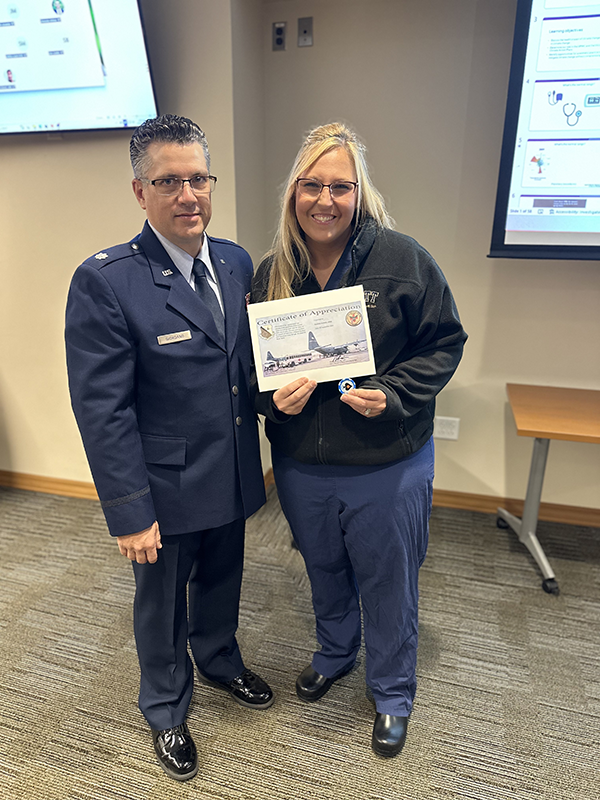 Lt Col Giordano presenting Dani with a personal certificate of appreciation and a challenge coin that was flown over Afghanistan in the final days of the war.