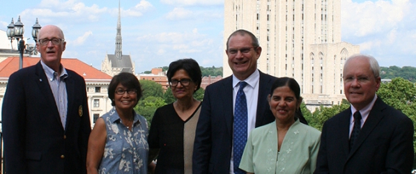 "The retirement party posing with Heinz chapel and the Cathedral of Learning in the background"