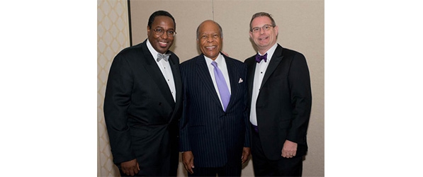 "Three men in formal wear posing for a photo"