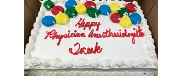 "A cake with the words Happy Physician Anesthesiologists Week and decorated with baloons"