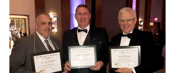 "Dongilli, O'Donnell, and Riley posing with awards"