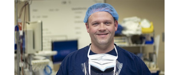 "Brett Fadgen in medical garb surrounded by equipment"