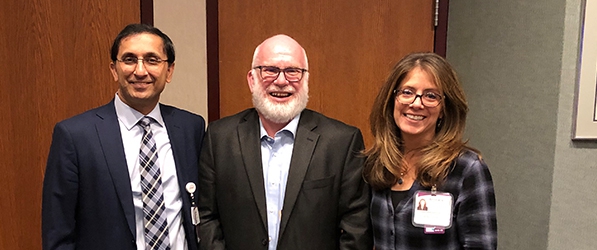 "Dan Devinney stands between Doctor Mahajan and Annmarie Lyons"