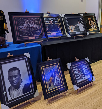 "A selection of framed photos of Pittsburgh athletes across different sports, some are autographed"