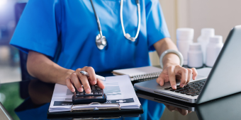 healthcare professional taking notes on a laptop