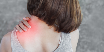 woman holding onto her neck in pain