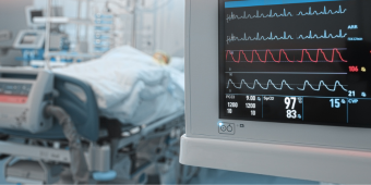 Photo of a patient room, with a focus on the vital signs monitor