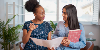 two young women talking to each other during a mentorship session