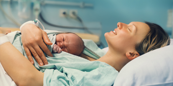 woman holding her newborn baby