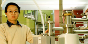 person standing next t a high field spectrometer