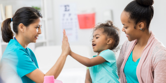 clinicians high-five a pediatric patient 